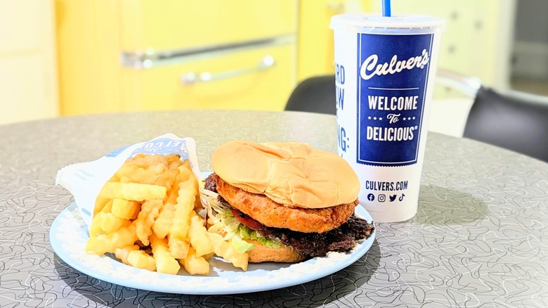The beloved CurderBurger on a plate with fries and a Culver's drink