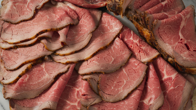 Thinly sliced roast beef on white plate.