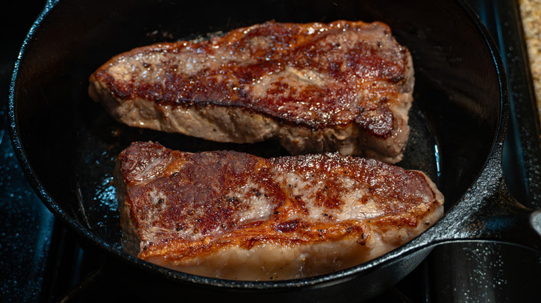 Two steaks with a brown crust in a frying pan