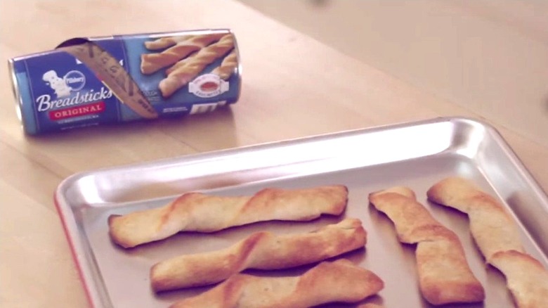 Pillsbury breadsticks on oven pan with Pillsbury tube in background