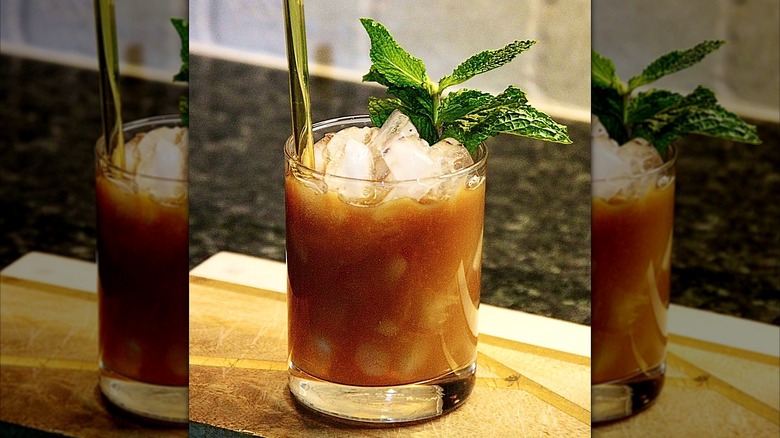 A sweet tea mule on a wooden tray with a straw