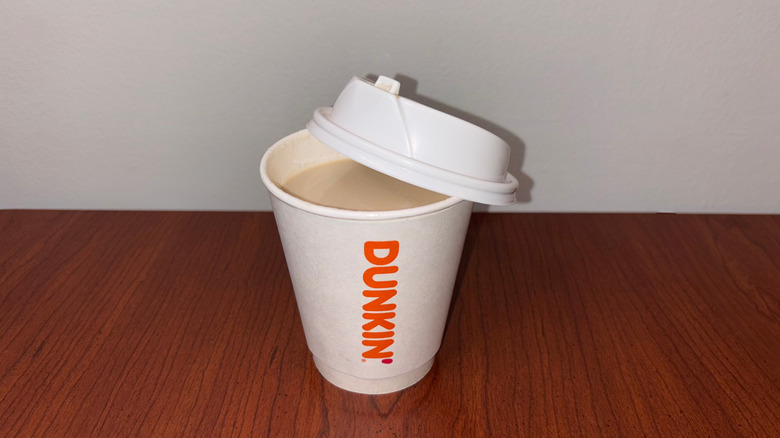 A very light chai latte in a Dunkin' to-go cup with the lid half off