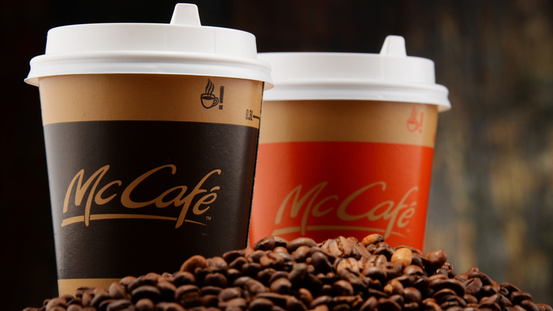 Two McCafe cups amongst coffee beans.