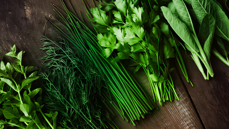 An array of fresh herbs on a wooden cutting board