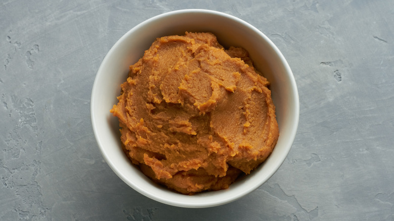 A bowl of miso paste on a grey background