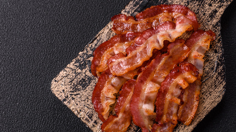 Fried bacon strips  on a wooden board