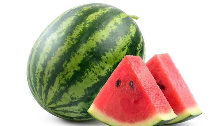Two watermelon slices are pictured with a whole watermelon