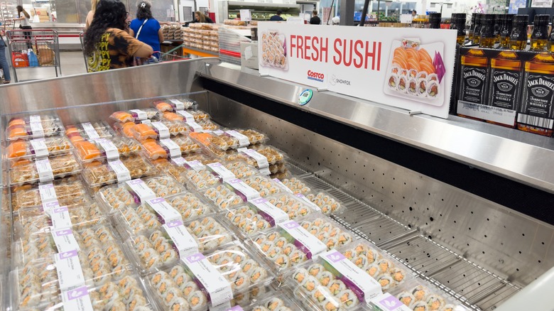 sushi rolls sitting in a refrigerator section in costco