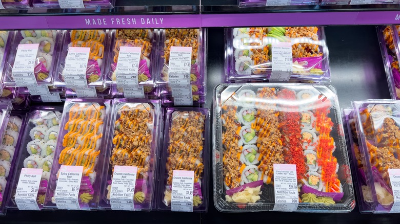 packaged sushi rolls sitting in a grocery store display case