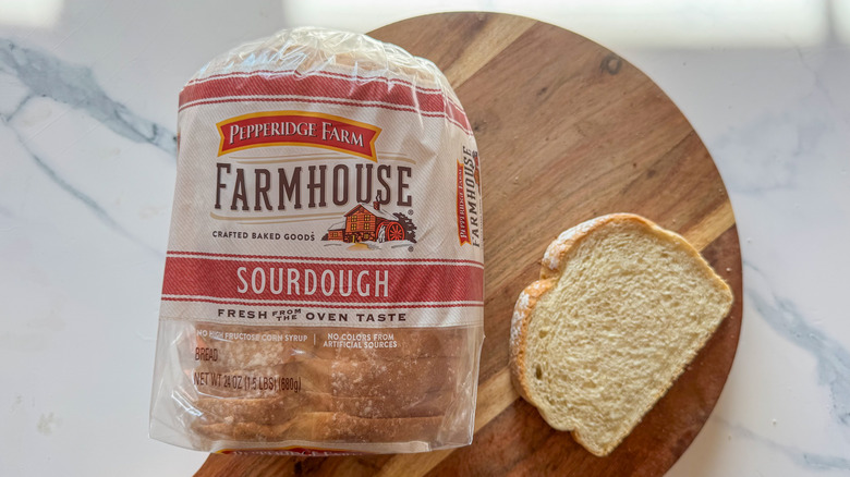 Pepperidge Farm sourdough bread in package with slice on wooden surface
