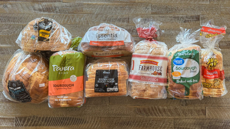 Sourdough bread loaves in wrappers on a wooden table