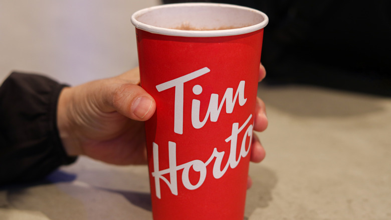 Person holding Tim's cup