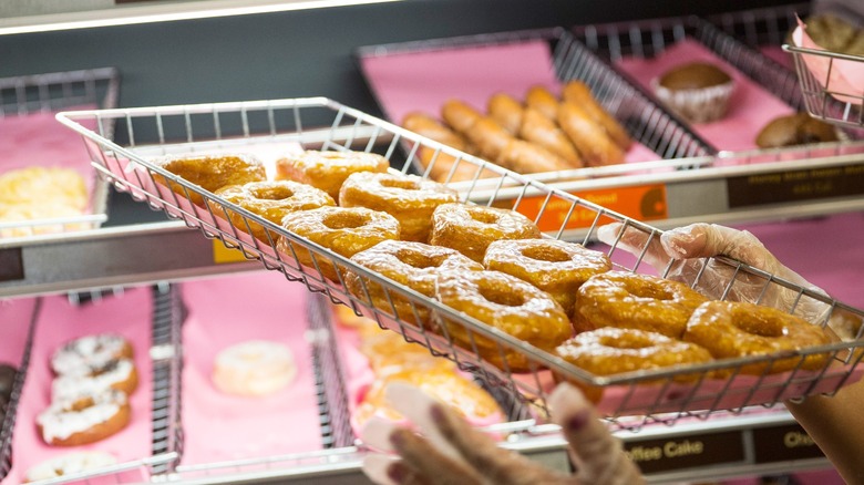 Dunkin' rack of donuts held by gloved hands