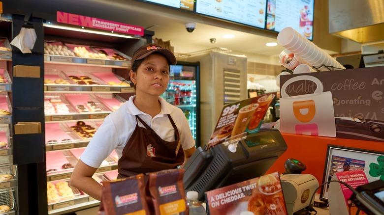 Dunkin' employee behind counter in uniform