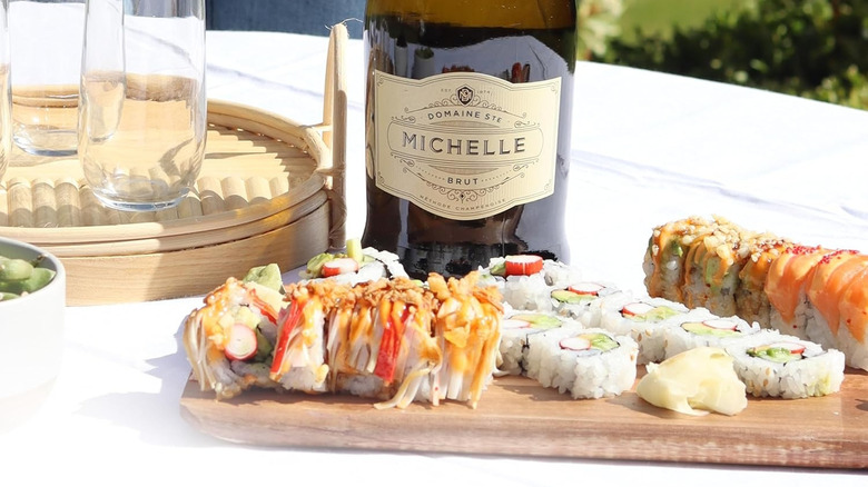 A bottle of Domaine Ste Michelle Brut behind a board lined with sushi