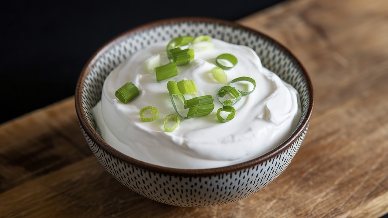 A bowl of sour cream with spring onions