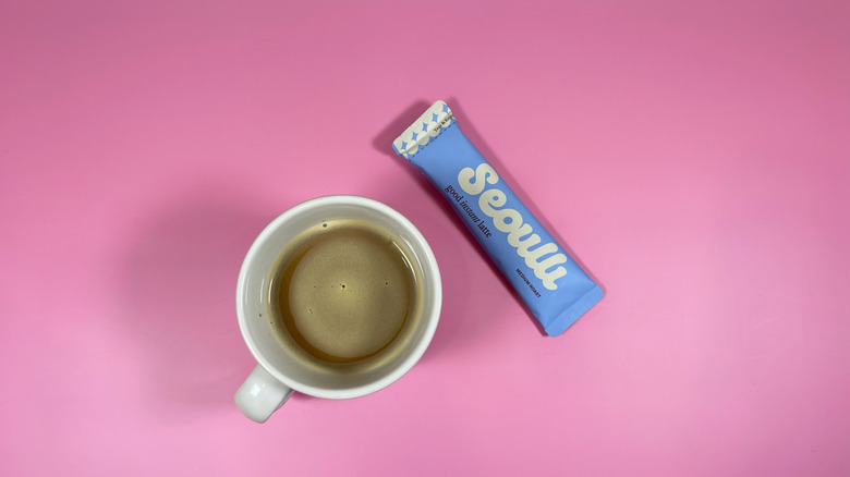 A packet of Seoulli's instant latte next to a mug