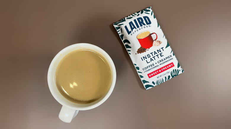 A Laird Superfood instant latte packet next to a mug