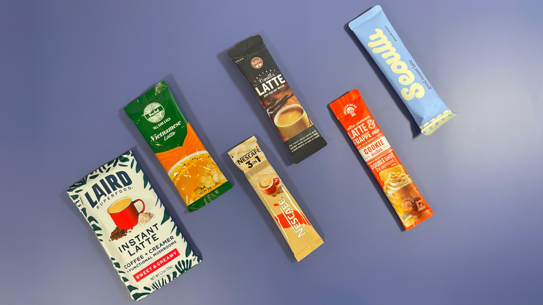 Several packets of instant latte mix on a blue background