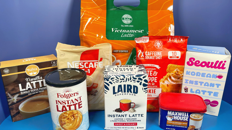 Several instant latte brands in their boxes on a blue background