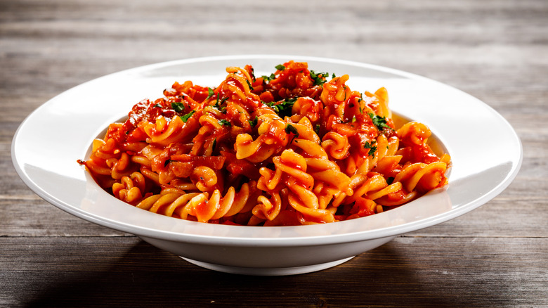 A tomato-based pasta dish in a white bowl
