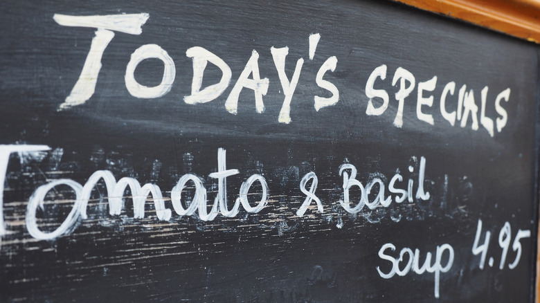 A chalkboard with "Today's specials" and "Tomato and Basil Soup" for 4.95 written on it