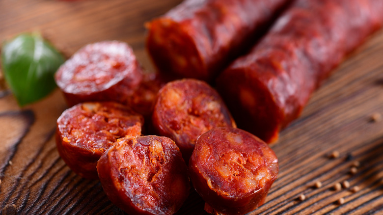 Spanish chorizo slices cut from a whole sausage on a cutting board