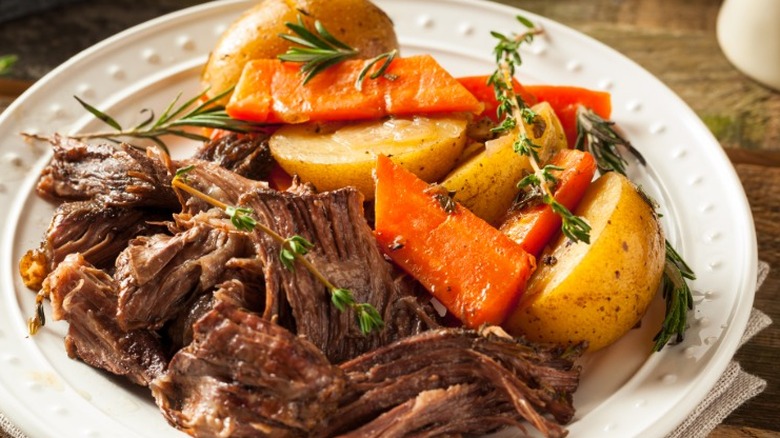 A completed pot roast dinner on a plate