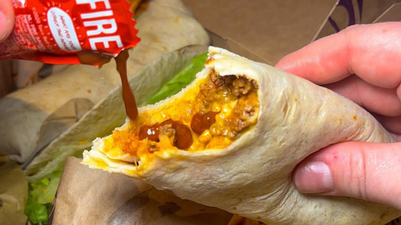Adding Fire sauce to a burrito