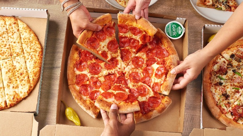 People sharing takeout yummy pepperoni pizza