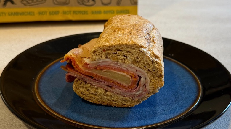 A sandwich with meats and cheese on a blue plate