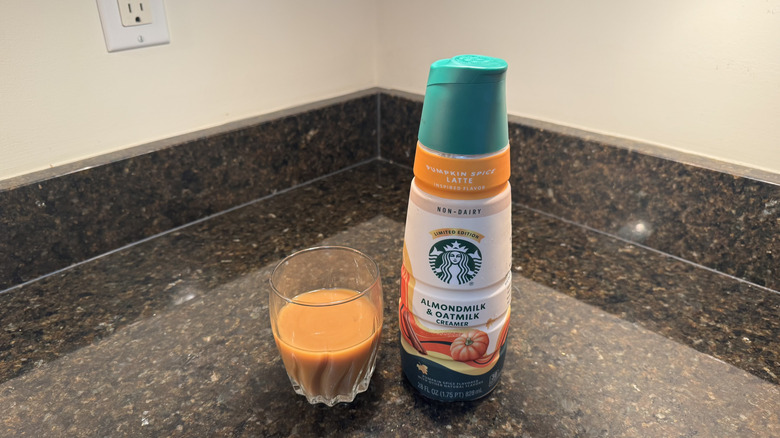 Starbucks pumpkin spice latte creamer and glass of coffee
