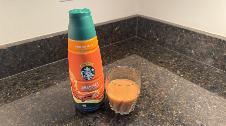 Starbucks pumpkin spice latte creamer and glass of coffee
