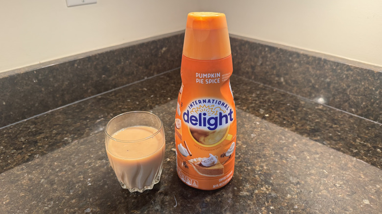 International Delight creamer and glass of coffee on a countertop