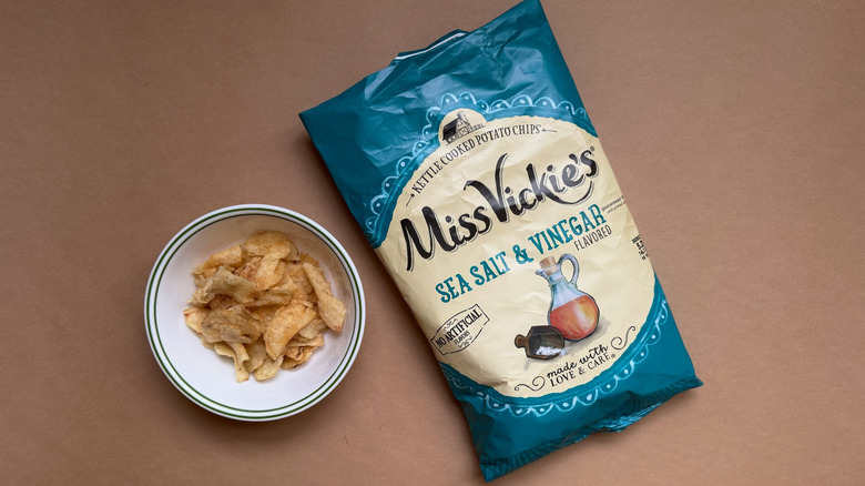 Bag and bowl of Miss Vickie's Kettle Cooked Sea Salt & Vinegar Chips on brown surface
