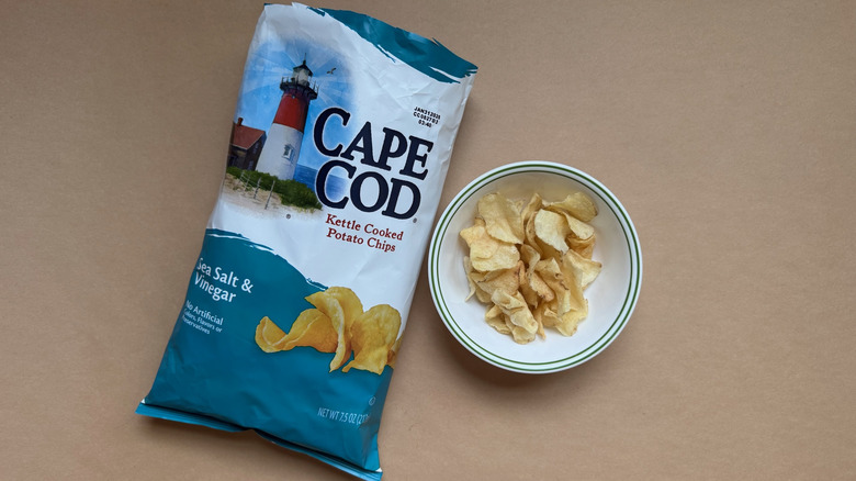 Bag and bowl of Cape Cod Kettle Cooked Sea Salt & Vinegar Chips on brown surface