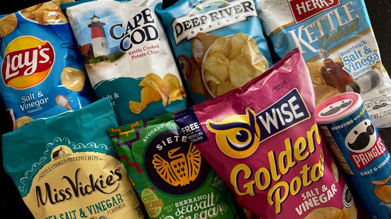 multiple bags of salt and vinegar chips on black table