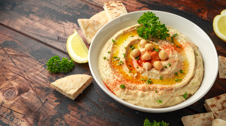 Bowl of hummus with olive oil and pita bread.