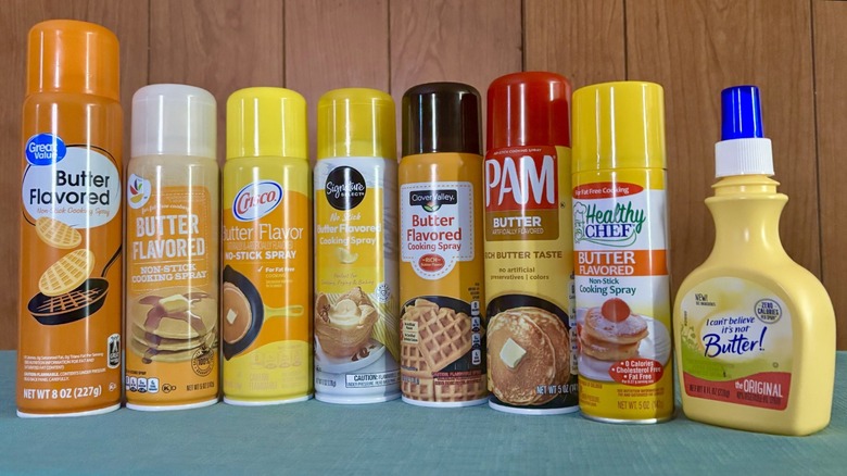 Eight butter flavored non-stick sprays in a line. From left - Great Value, Stop & Shop, Crisco, Signature Select, Clover Valley, PAM, Healthy Chef, and I Can't Believe It's Not Butter!