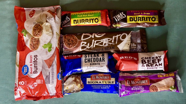 An 8 pack of Great Value Beef & Bean burritos next to an assembly of 7 other single serve burritos - from top left, Tina's Red Hot Beef, Tina's Beef and Bean, Tina's Big Burrito Beef and Bean, Red's Steak and Cheddar, Red's Cheesy Beef and Bean, El Monterey Signature Shredded Steak and Cheese, and El Monterey Beef and Bean Burrito