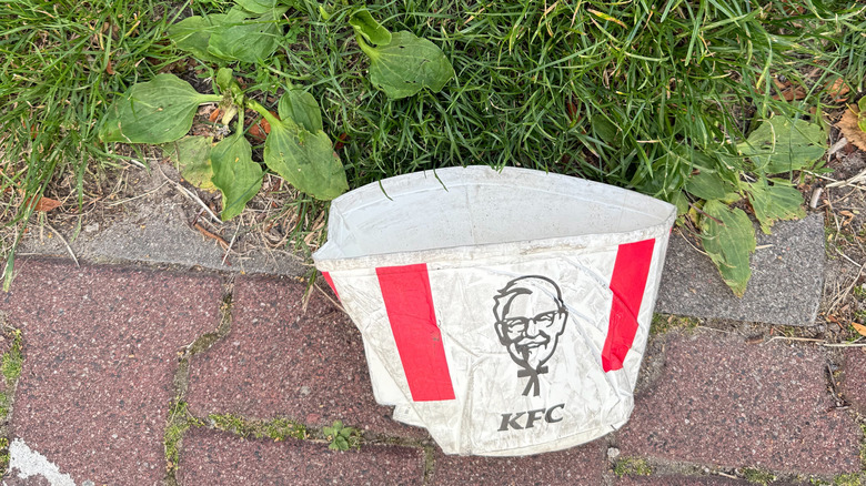 Crumpled KFC bucket on ground