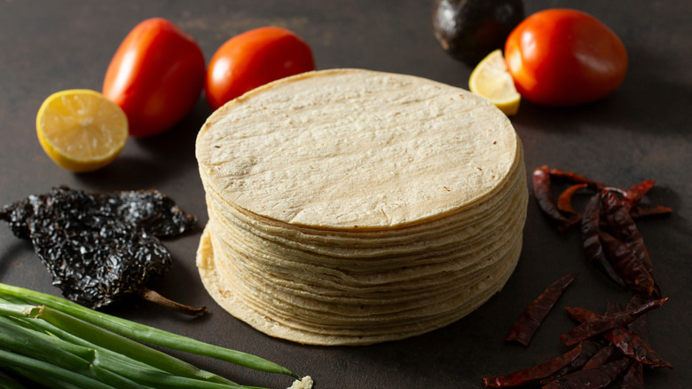A stack of corn tortillas with chiles and tomatoes