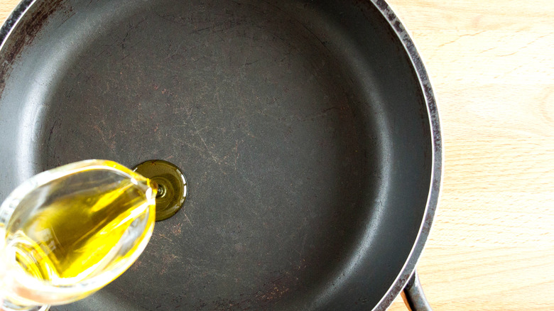 Cooking oil being added to a frying pan