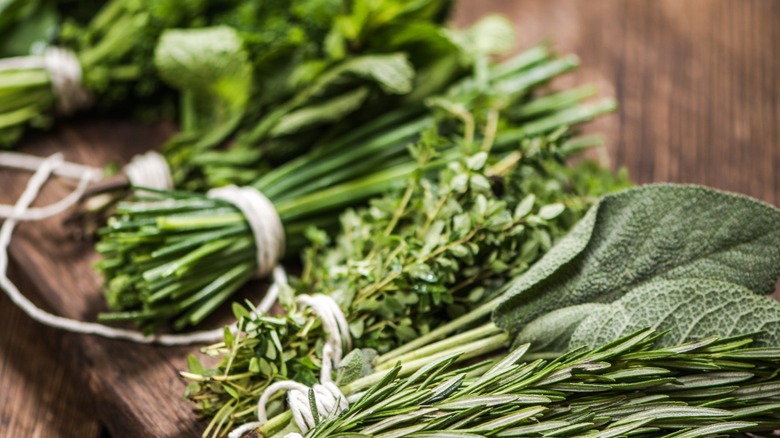 Bundles of fresh herbs on a wooden surface