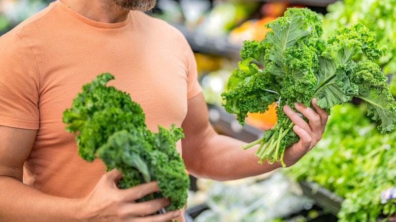 Man buying kale in the grocery store