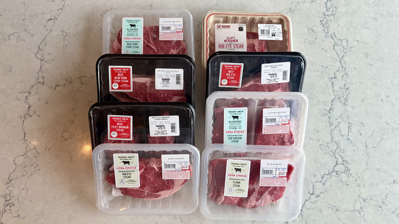 Two lines of eight packaged raw steaks from Trader Joe's