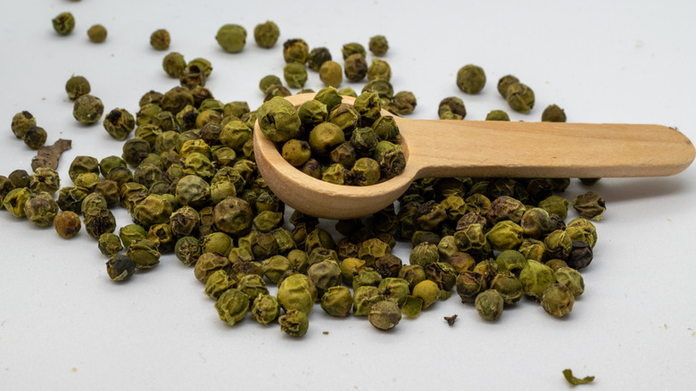 Green peppercorns with a spoon