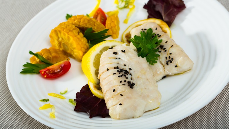 steamed hake with vegetables on plate