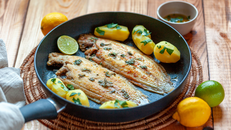 sole in pan with potatoes and herbs