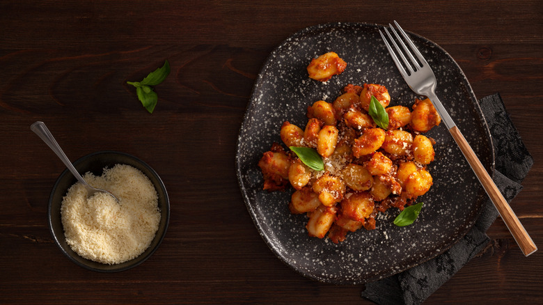 Baked gnocchi in a tomato sauce on a black plate